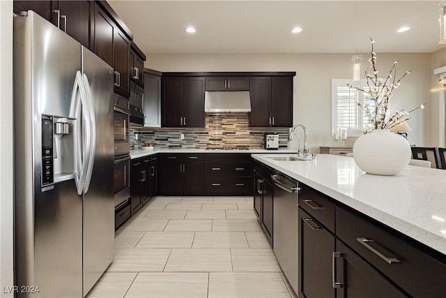 kitchen with sink, hanging light fixtures, appliances with stainless steel finishes, and dark brown cabinetry