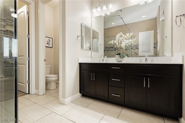 bathroom with toilet, vanity, tile patterned flooring, and a tile shower