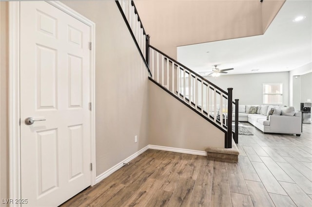 stairway with ceiling fan and hardwood / wood-style flooring