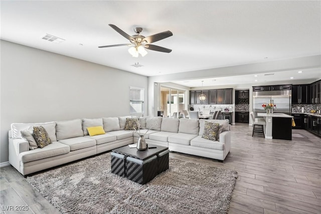 living room with ceiling fan and hardwood / wood-style floors