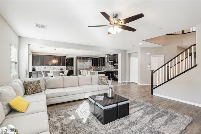 living room featuring ceiling fan and dark hardwood / wood-style flooring