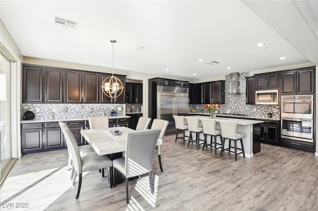 dining space with light wood-type flooring and an inviting chandelier