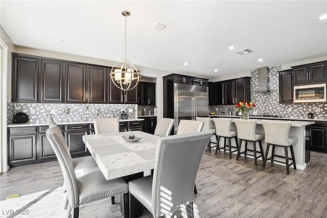 dining room with light hardwood / wood-style floors and a notable chandelier