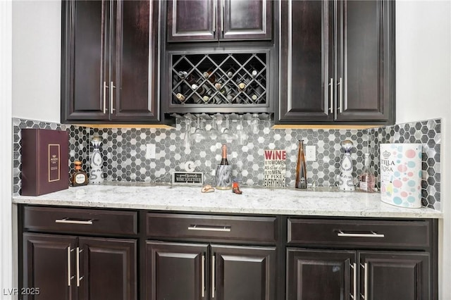 bar featuring decorative backsplash and dark brown cabinets