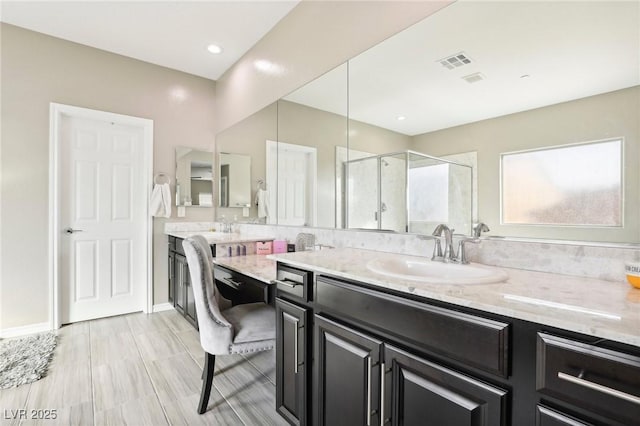 bathroom with walk in shower and vanity