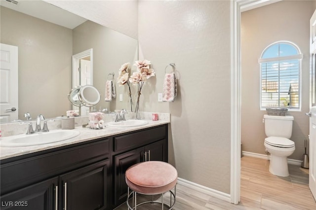 bathroom with toilet, vanity, and hardwood / wood-style flooring