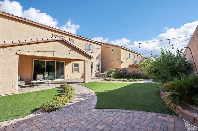 back of property with a lawn and a patio