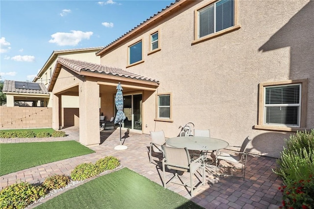 back of house featuring a patio area and solar panels