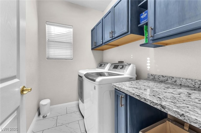 clothes washing area featuring independent washer and dryer and cabinets