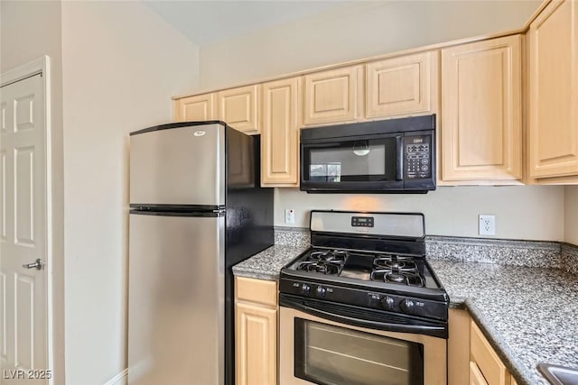 kitchen with light stone counters, light brown cabinets, and stainless steel appliances