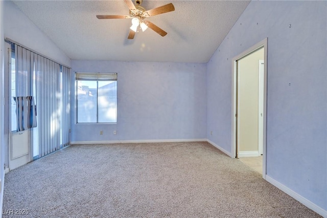 carpeted empty room with ceiling fan, lofted ceiling, and a textured ceiling