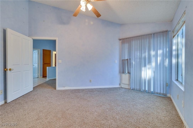 carpeted spare room featuring ceiling fan, lofted ceiling, and a textured ceiling