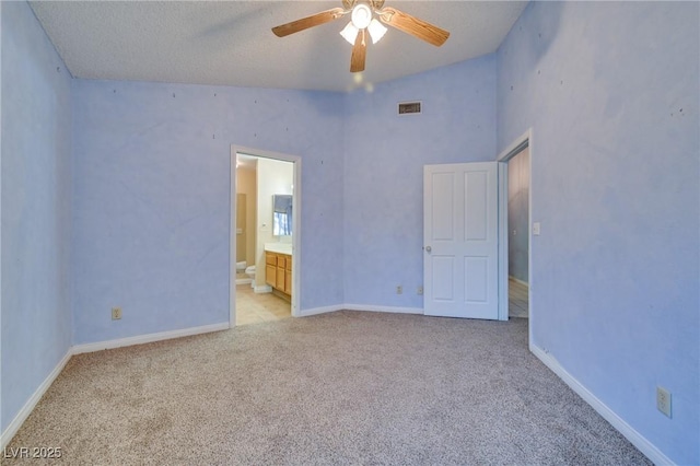 empty room featuring light carpet, a textured ceiling, vaulted ceiling, and ceiling fan