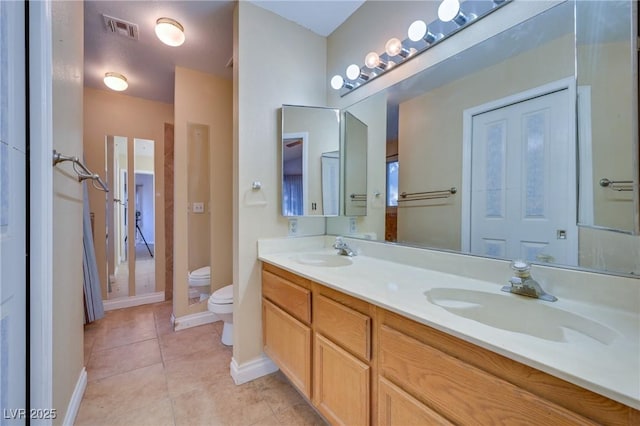 bathroom with vanity, toilet, and tile patterned flooring