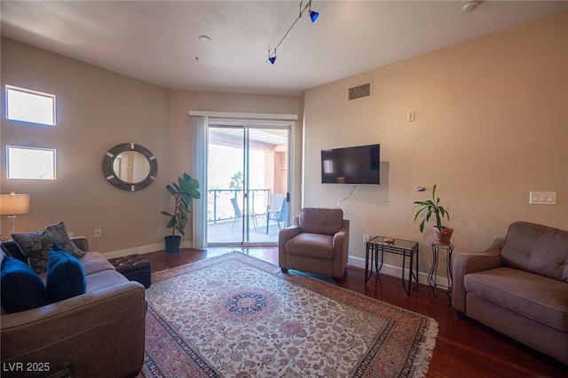 living room with dark hardwood / wood-style floors and track lighting