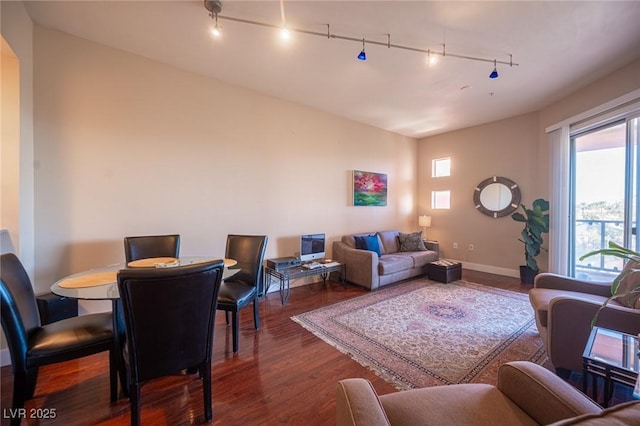 living room featuring dark wood-type flooring and rail lighting