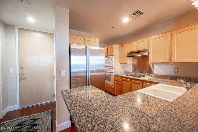 kitchen with dark hardwood / wood-style floors, kitchen peninsula, sink, white appliances, and light stone counters