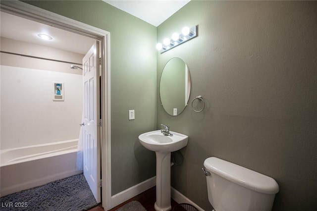 bathroom with toilet, sink, and a bath