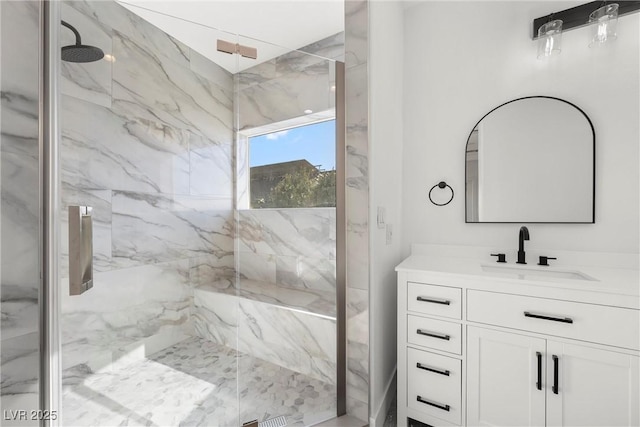 bathroom with tiled shower and vanity