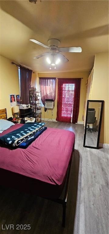 bedroom featuring ceiling fan, cooling unit, and wood-type flooring