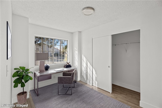 home office with a textured ceiling and hardwood / wood-style floors