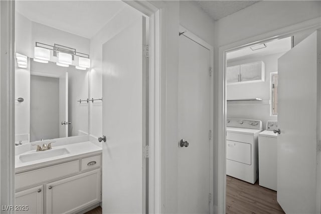 bathroom featuring vanity, separate washer and dryer, and hardwood / wood-style flooring