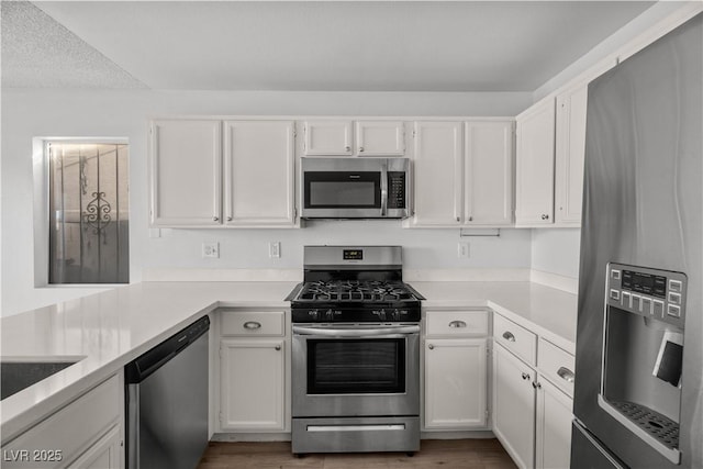 kitchen featuring stainless steel appliances, dark hardwood / wood-style flooring, and white cabinetry