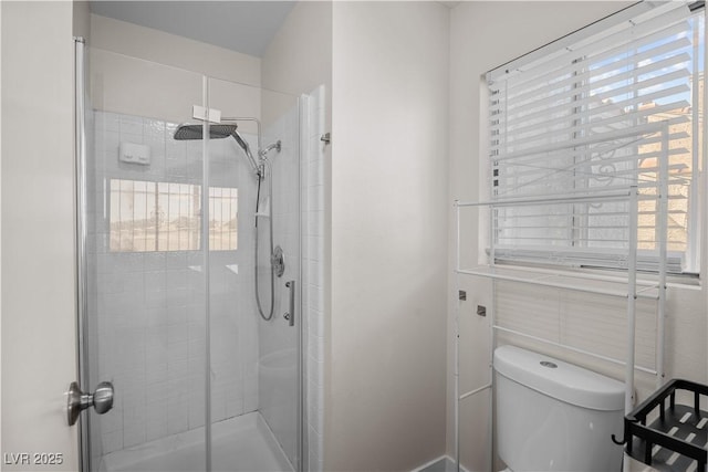 bathroom featuring plenty of natural light, toilet, and walk in shower