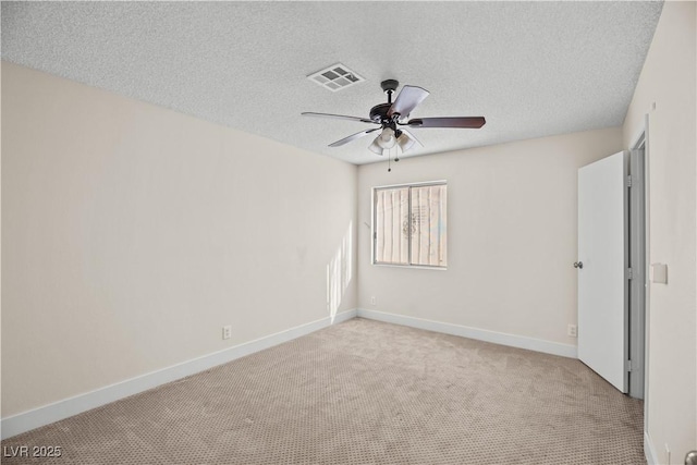 spare room featuring ceiling fan, a textured ceiling, and light carpet