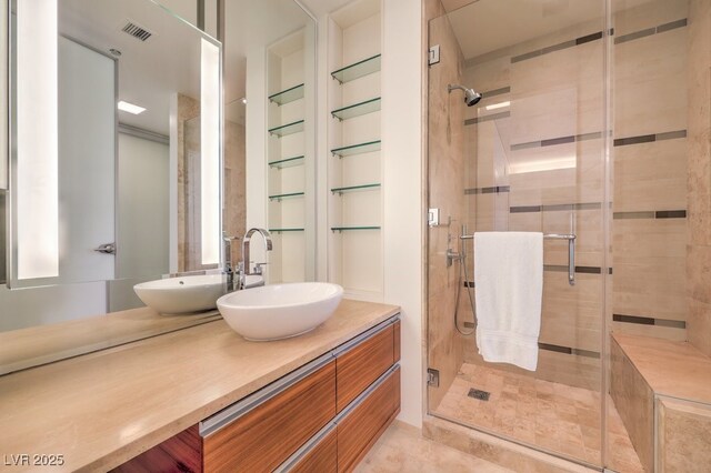 bathroom featuring a shower with shower door and vanity