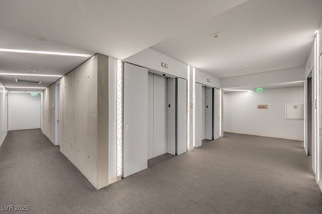 hallway with carpet floors and elevator