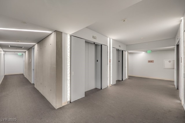 corridor featuring elevator and carpet flooring