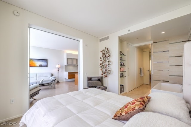 bedroom featuring a barn door and light tile patterned floors