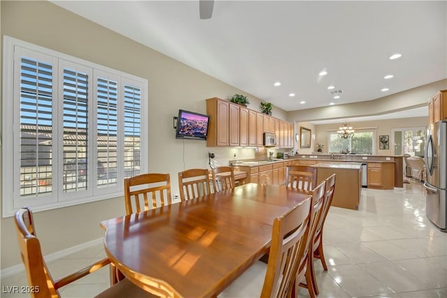 tiled dining space featuring a notable chandelier