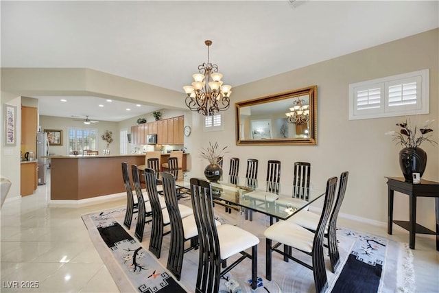 dining area featuring ceiling fan with notable chandelier