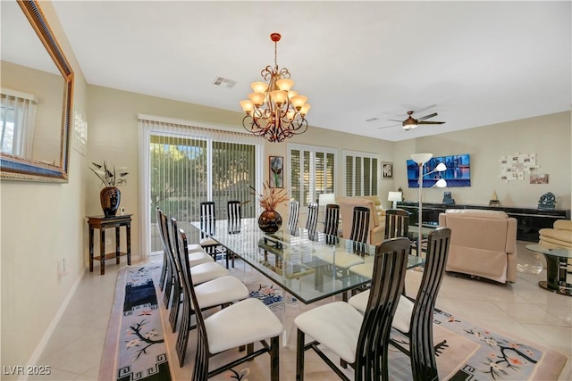 tiled dining room featuring ceiling fan with notable chandelier