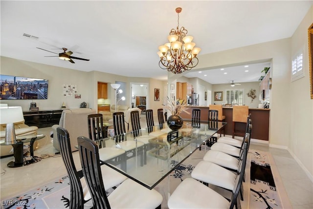 dining room featuring light tile patterned flooring and ceiling fan with notable chandelier