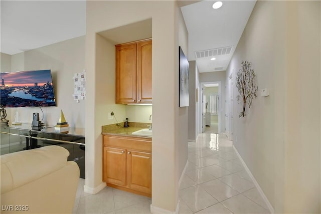 hall with light tile patterned floors and sink