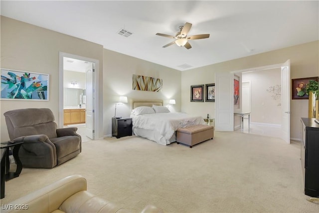 carpeted bedroom featuring ceiling fan and ensuite bath