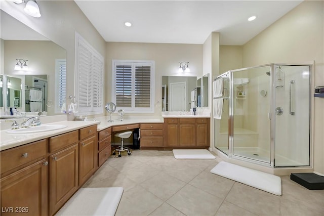 bathroom with an enclosed shower, vanity, and tile patterned flooring