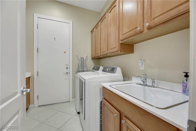 laundry room with cabinets, light tile patterned floors, sink, and washing machine and dryer