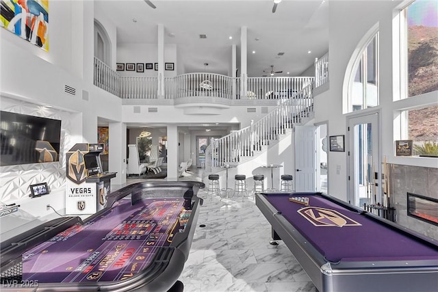 recreation room with ceiling fan, a high ceiling, billiards, and a healthy amount of sunlight