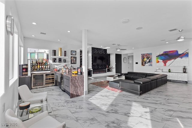 living room with bar, ceiling fan, and wine cooler