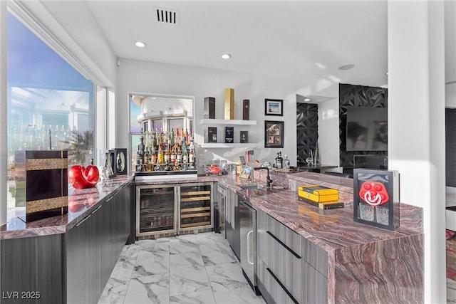 bar with wine cooler, dark stone counters, and sink