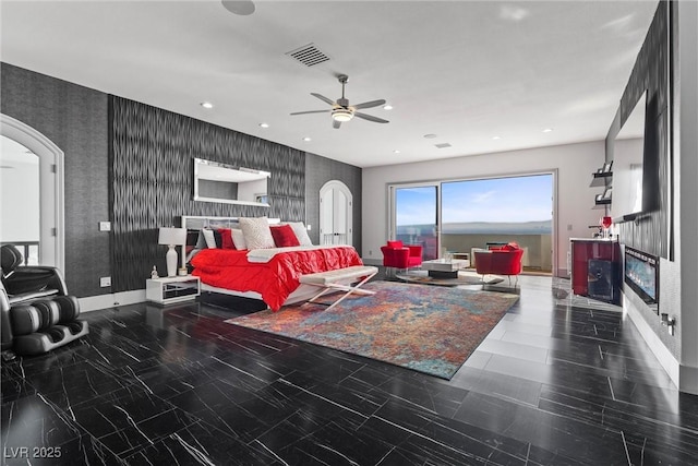 bedroom with ceiling fan and a fireplace