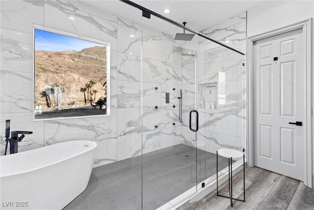 bathroom featuring tile walls, hardwood / wood-style flooring, and separate shower and tub