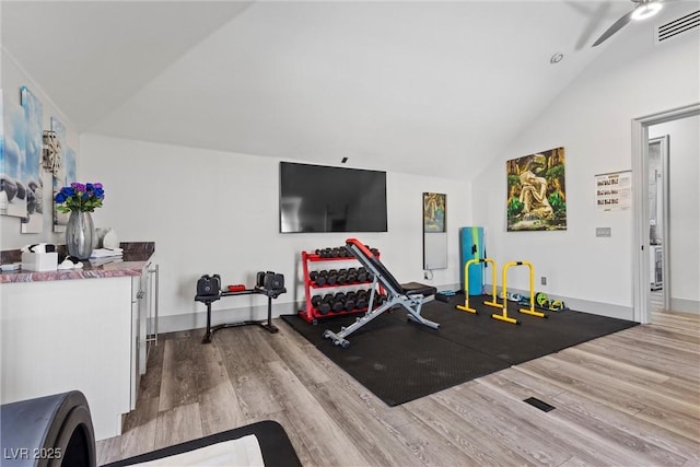 exercise area with ceiling fan, hardwood / wood-style flooring, and vaulted ceiling