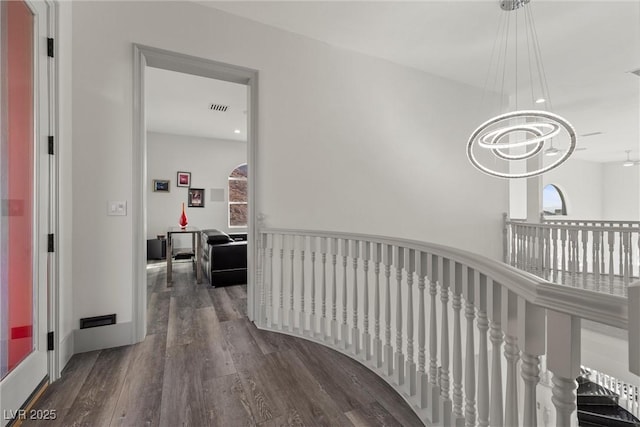 hallway featuring dark hardwood / wood-style flooring and a notable chandelier