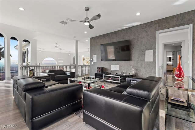 living room with ceiling fan and light hardwood / wood-style floors