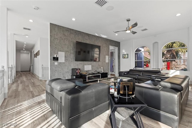 living room with light hardwood / wood-style flooring and ceiling fan